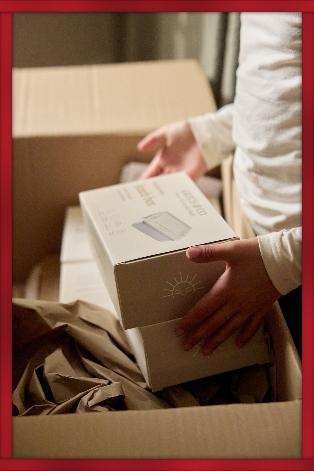 GRECH & CO. gift card: hands lifting a GRECH & CO. box out of a delivery carton, framed in red ribbon