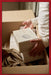 GRECH & CO. gift card: hands lifting a GRECH & CO. box out of a delivery carton, framed in red ribbon